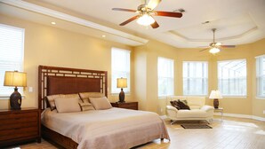 A bedroom with a large bed, two nightstands, a chair, and a ceiling fan. - A beautiful spot to unwind, relax and enjoy quality time with family and friends (Cape Coral)