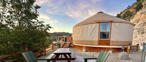 A yurt with a fire pit and outdoor seating area.