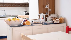 A kitchen with a bowl of pastries, a kettle, and jars of jam. - Rosanna Maison B&B (Ischia)