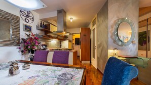 Una cocina moderna con estufa a gas, armarios de madera y un espejo decorativo.
