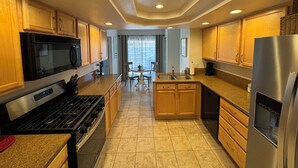 A modern kitchen with wooden cabinets, stainless steel appliances, and a central island.