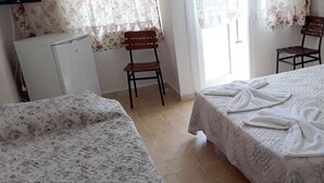 A room with two beds, a TV, a small desk, and a chair.