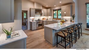 A spacious kitchen with a large island, modern appliances, and ample natural light. - Mountain Modern Home in the Signature Collection at Old Greenwood! (Truckee)