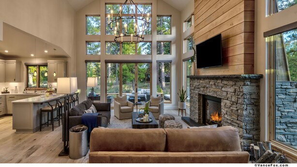 A spacious living area with a fireplace, large windows, and a kitchen with a bar. - Mountain Modern Home in the Signature Collection at Old Greenwood! (Truckee)