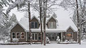 A two-story house with a snow-covered roof and a brick exterior. - Walk To The Lake, Beach, Indoor Waterpark And Downtown (Mackinaw City)