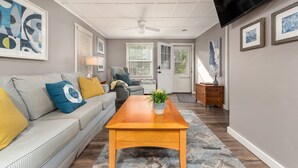 Ein Wohnzimmer mit Sofa, Couchtisch und Kunstwerken an den Wänden.