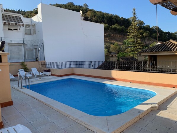Una piscina al aire libre de temporada, sillones reclinables de piscina