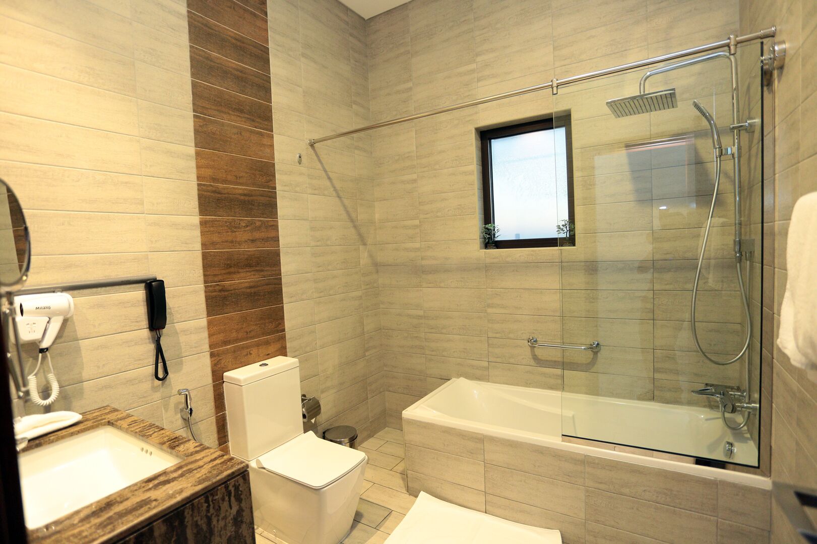 Un baño moderno con ducha envuelta en vidrio, inodoro y lavamanos.