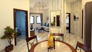 A spacious living room with a marble floor, a round dining table, and a large mirror. - Marbella Holiday Homes (Dubai)