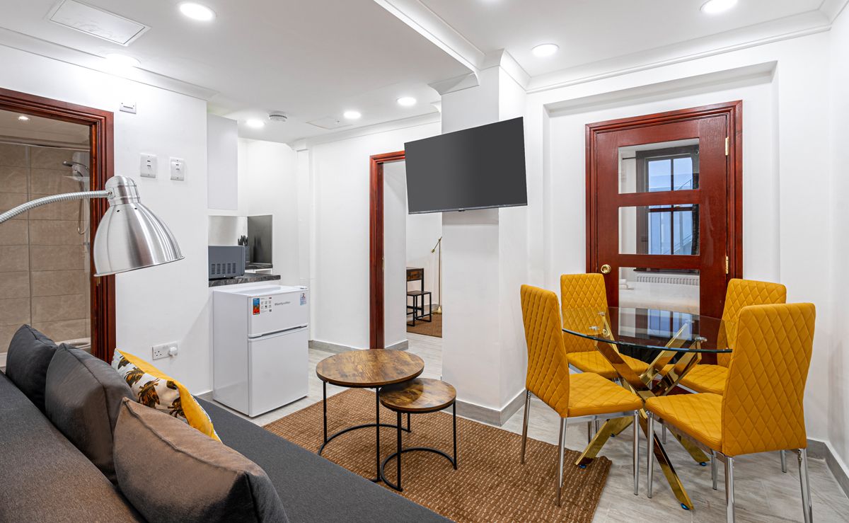 Un apartamento estándar con sala de estar, kitchenette y comedor.