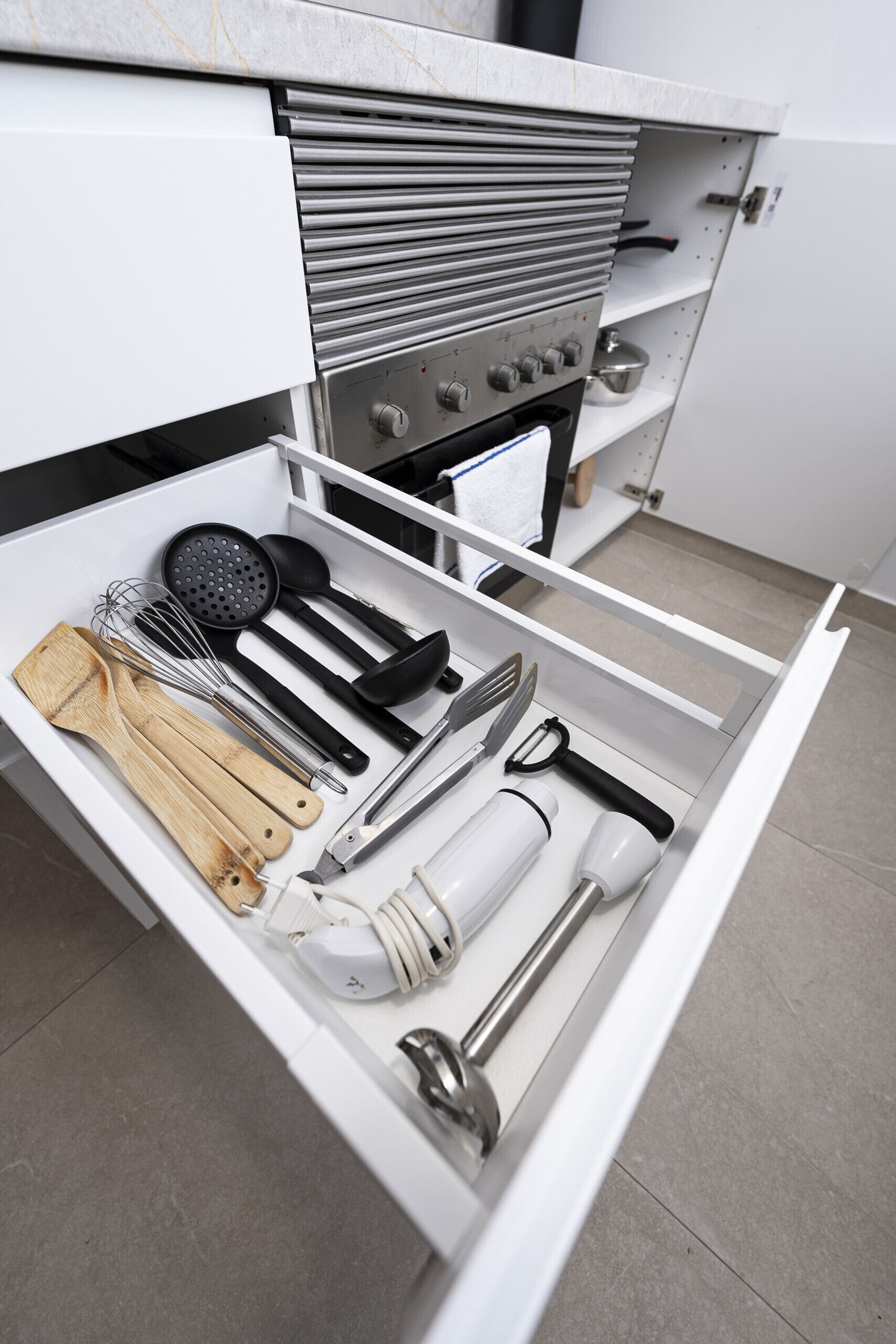Un cassetto della cucina con vari utensili e elettrodomestici.