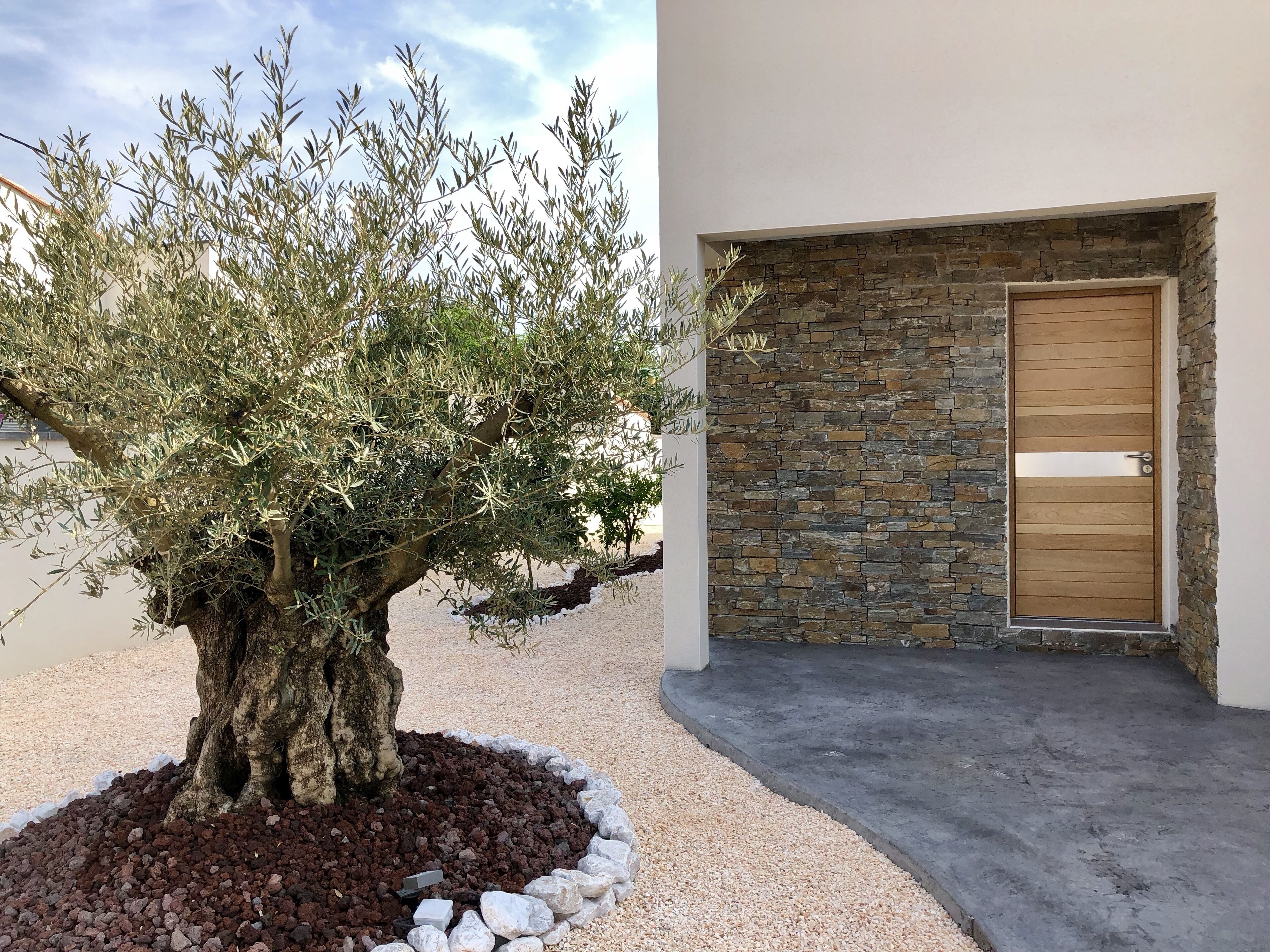 Un edificio moderno con fachada de piedra y puerta de madera.
