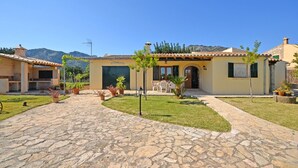 A stone-paved courtyard with a building featuring a tiled roof and a covered outdoor seating area. - Tabou - Country house for 6 people with private pool in Mallorca (Selva)