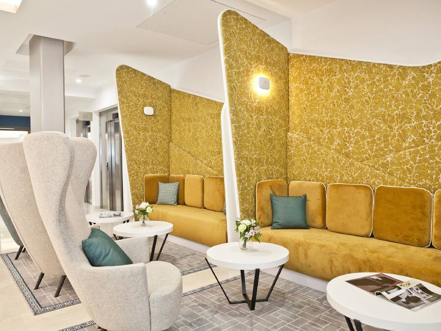 A modern lounge area with a sofa, armchairs, and a coffee table.
