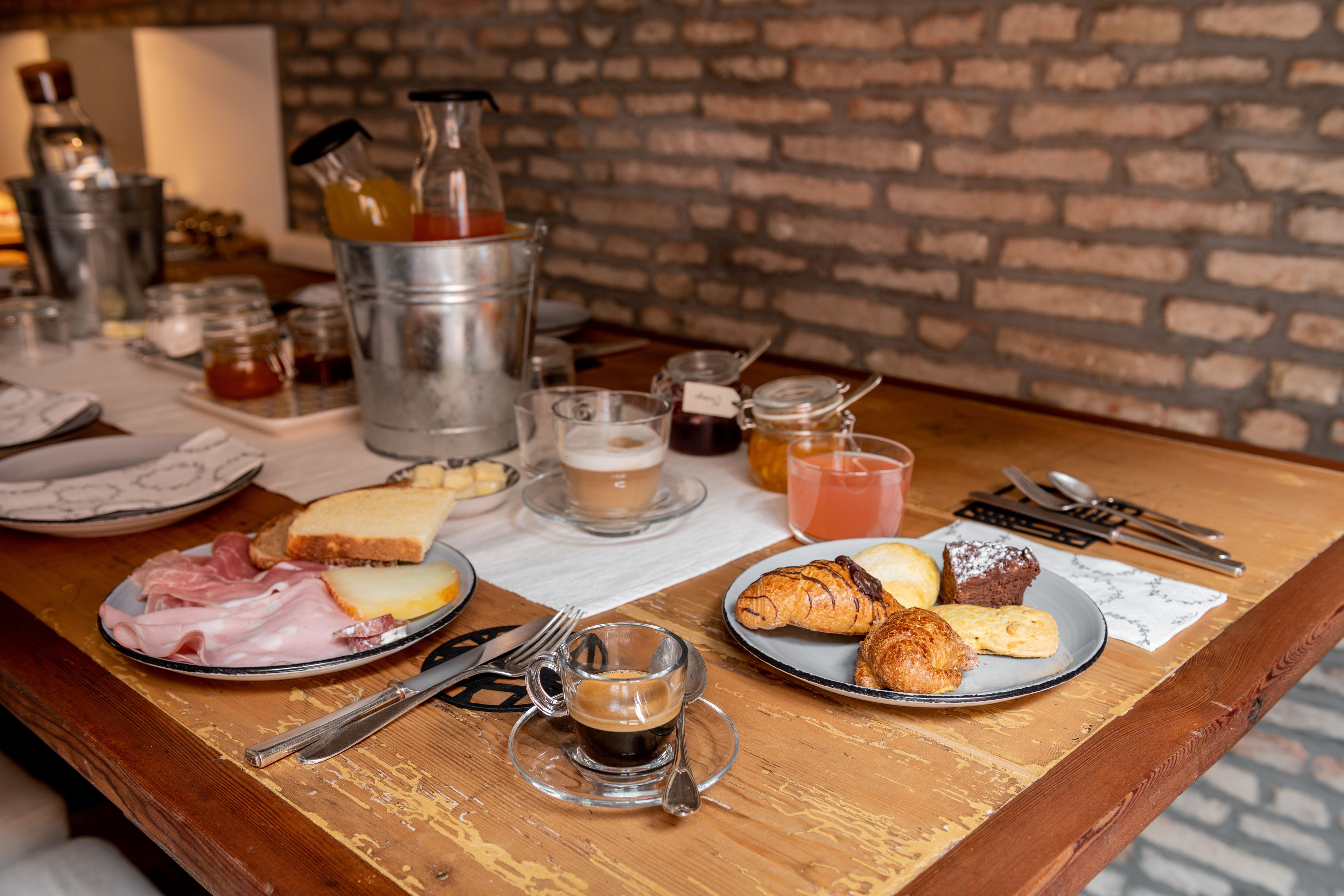 A breakfast table with plates of food, a coffee cup, and various condiments. - Good Morning Bologna (Bologna)