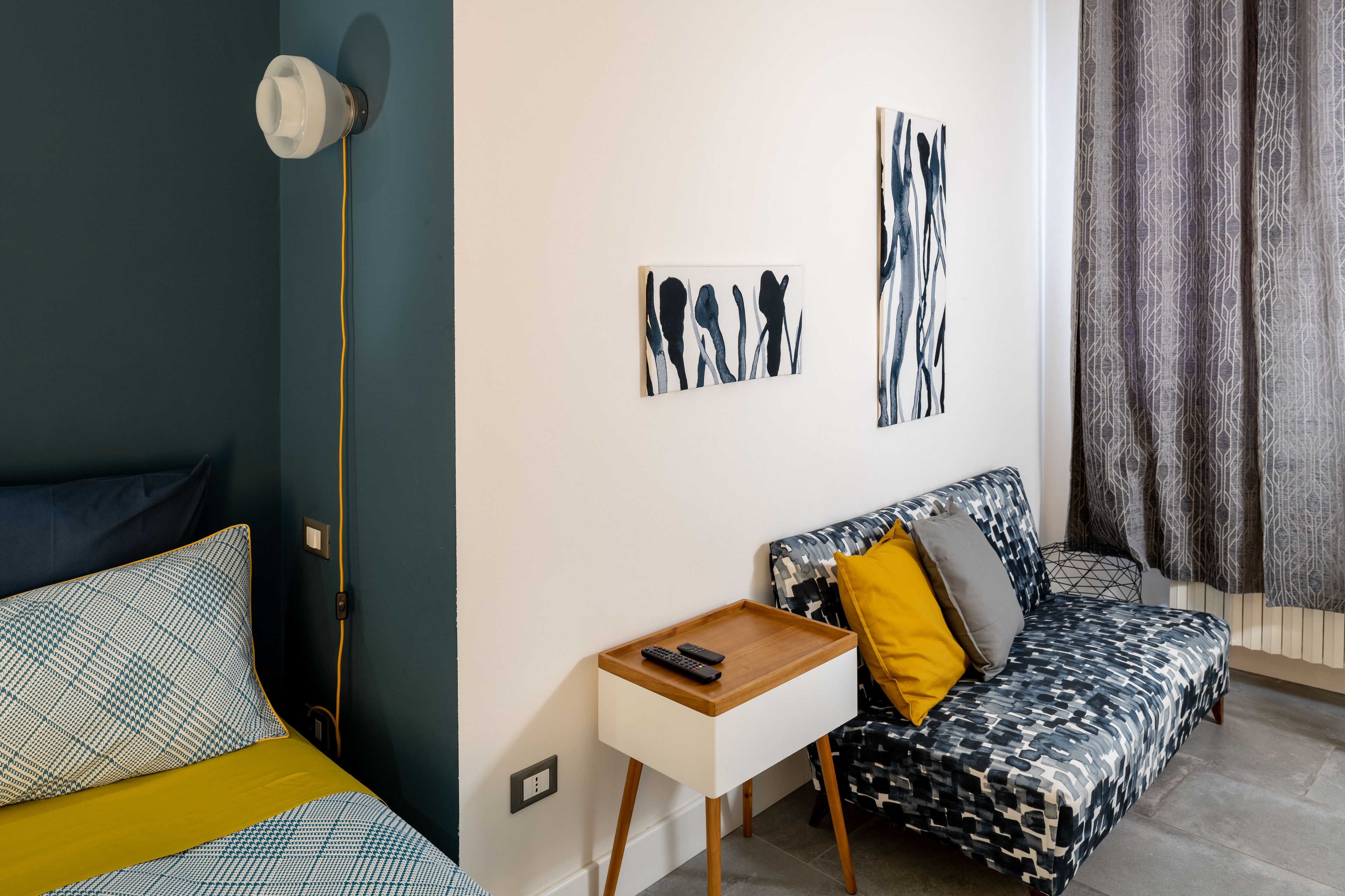 Un saló modern amb un sofà, una taula auxiliar petita i obra d'art a la paret.