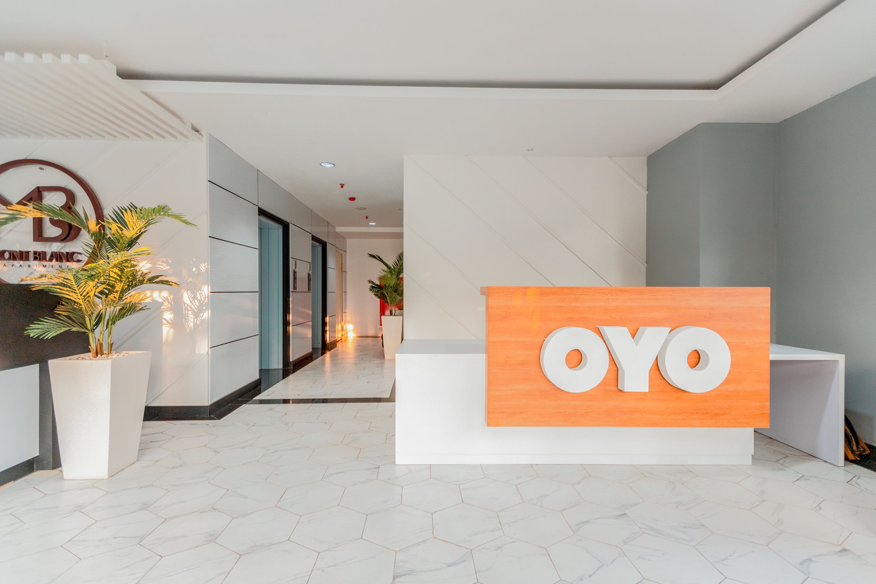 A reception area with a sign that reads "OYO" and a logo for "ONE BLANC APARTMENTS".