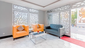 Un salon moderne avec deux canapés, une table basse et des paravents décoratifs.