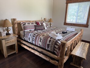A bed with a patterned bedspread, wooden headboard, and side tables with lamps and a tissue box. - 2BR, 1B, Sleeps 4, Lakeview and Lake access in West Glacier (West Glacier)