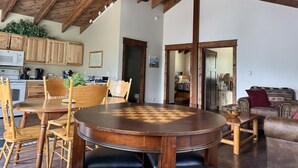 A spacious living area with a wooden ceiling, a round wooden table, and a brown leather sofa. - 2BR, 1B, Sleeps 4, Lakeview and Lake access in West Glacier (West Glacier)