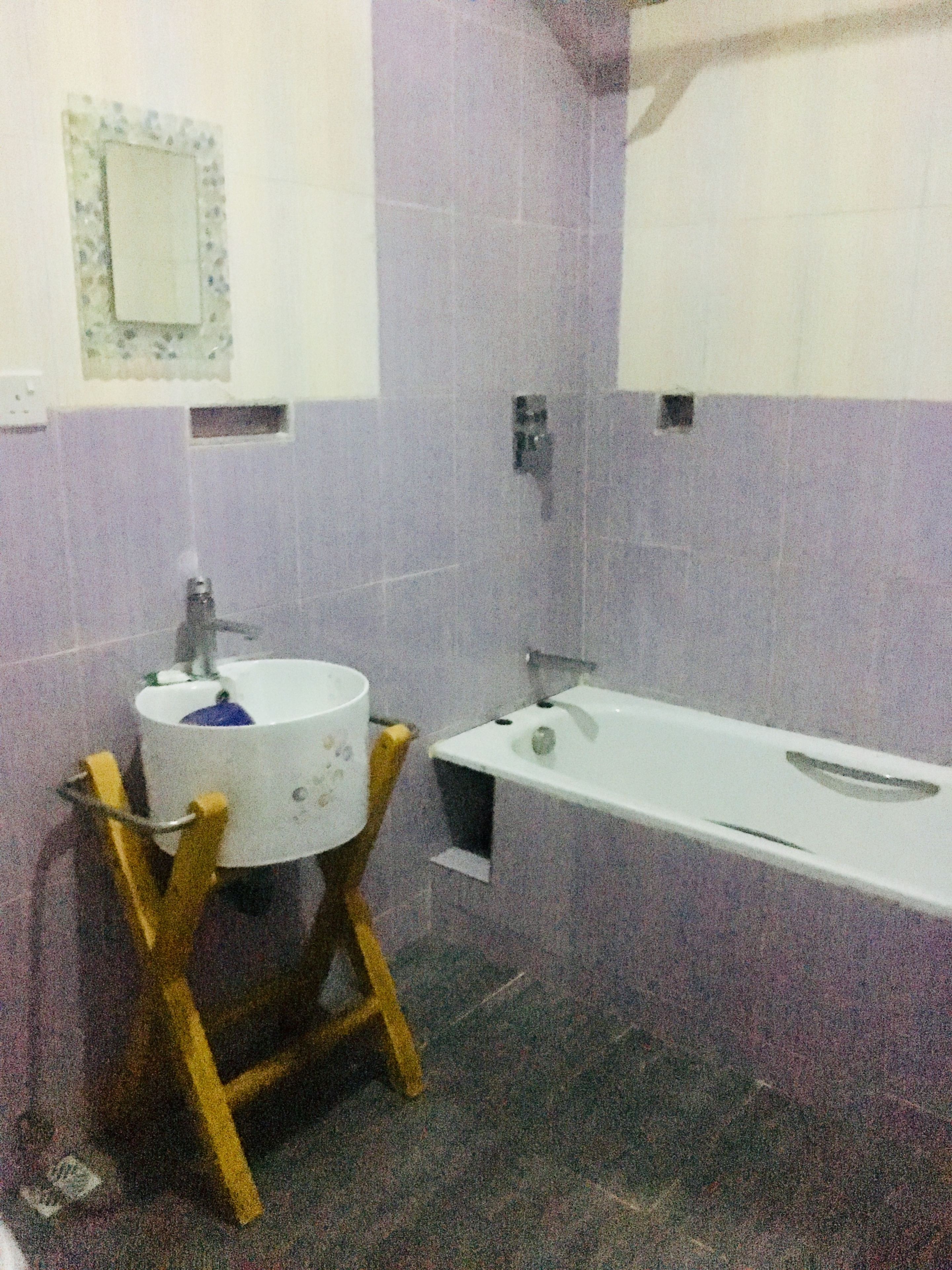 A bathroom with a sink, mirror, and bathtub.