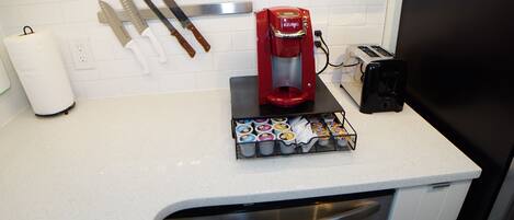 Eine Küche mit Kaffeemaschine, Toaster und einer Kapselbox für Kaffee.