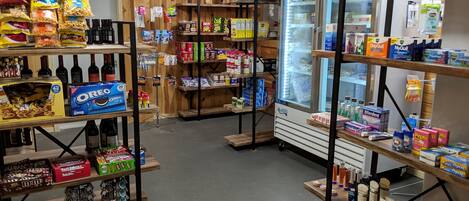 A store with shelves stocked with snacks, beverages, and household items.