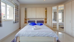 A modern bedroom with a bed, a wardrobe, and a mirror. - Centric and Spacious Apartment With Wifi and Balcony (Gzira)