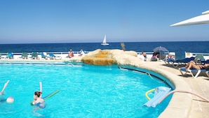 A pool area with lounge chairs and a view of the sea. - Centric and Spacious Apartment With Wifi and Balcony (Gzira)