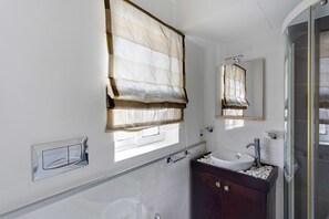 Un bagno con un'ampia finestra, un lavandino e uno specchio.