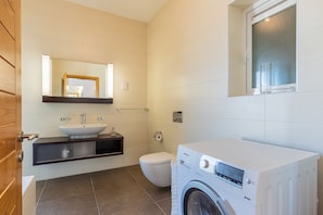A modern bathroom with a sink, toilet, and washing machine. - THE Most Incredible View IN Malta, INC Pool (Sliema)