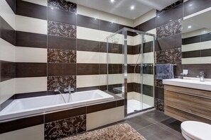 A modern bathroom with a glass-enclosed shower, a large bathtub, and a vanity with a mirror. - Contemporary, Luxury Apartment With Valletta and Harbour Views (Sliema)