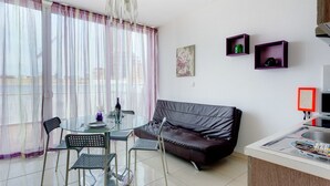 A compact living space with a dining area, a sofa, and a kitchenette. - Modern Penthouse in the Heart of Saint Julian's (St. Julian's)