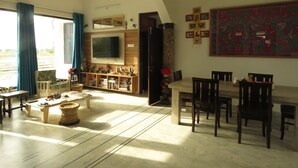 Un soggiorno spazioso con una grande TV, mobili in legno e un'area pranzo.