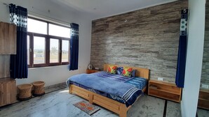 Una camera da letto con un letto in legno, un armadio e un'ampia finestra con tende.