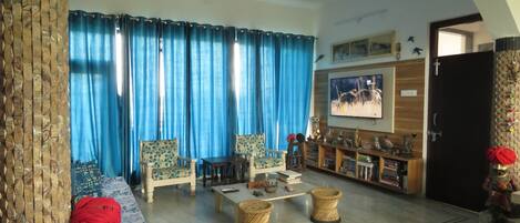 A living room with a sofa, chairs, a coffee table, and a television.