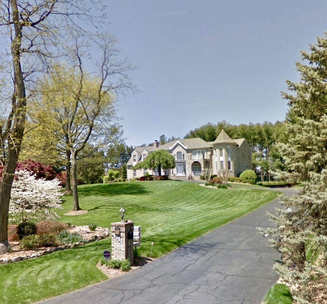 A large, two-story house with a well-maintained lawn and driveway.