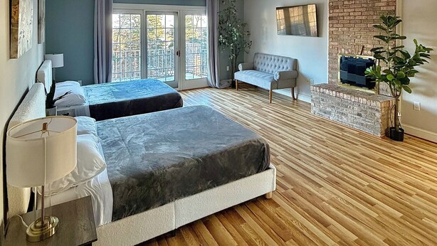 Una habitación de hotel moderna con una cama grande, un sofá y un pequeño rincón de descanso.