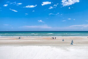 Une plage avec un ciel dégagé et une mer calme.