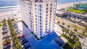 Un hôtel à plusieurs étages doté d’un parking et offrant une vue sur la plage.