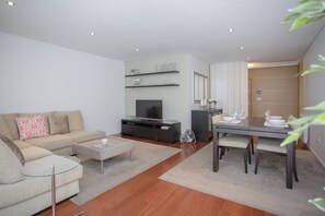 Apartamento Deluxe, 2 habitaciones | Zona de estar | Una televisión de pantalla plana