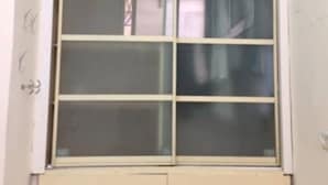 Una ventana con un diseño de cuadrícula, un interruptor de luz y un pequeño compartimento debajo.