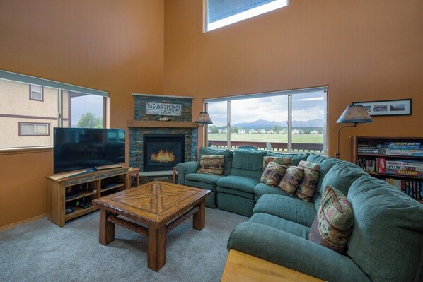 TV connectée, cheminée, livres, chaîne hi-fi