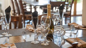 A dining table set with wine glasses, a bottle of champagne, and a folded napkin. - Hotel Viand (Sunny Beach)