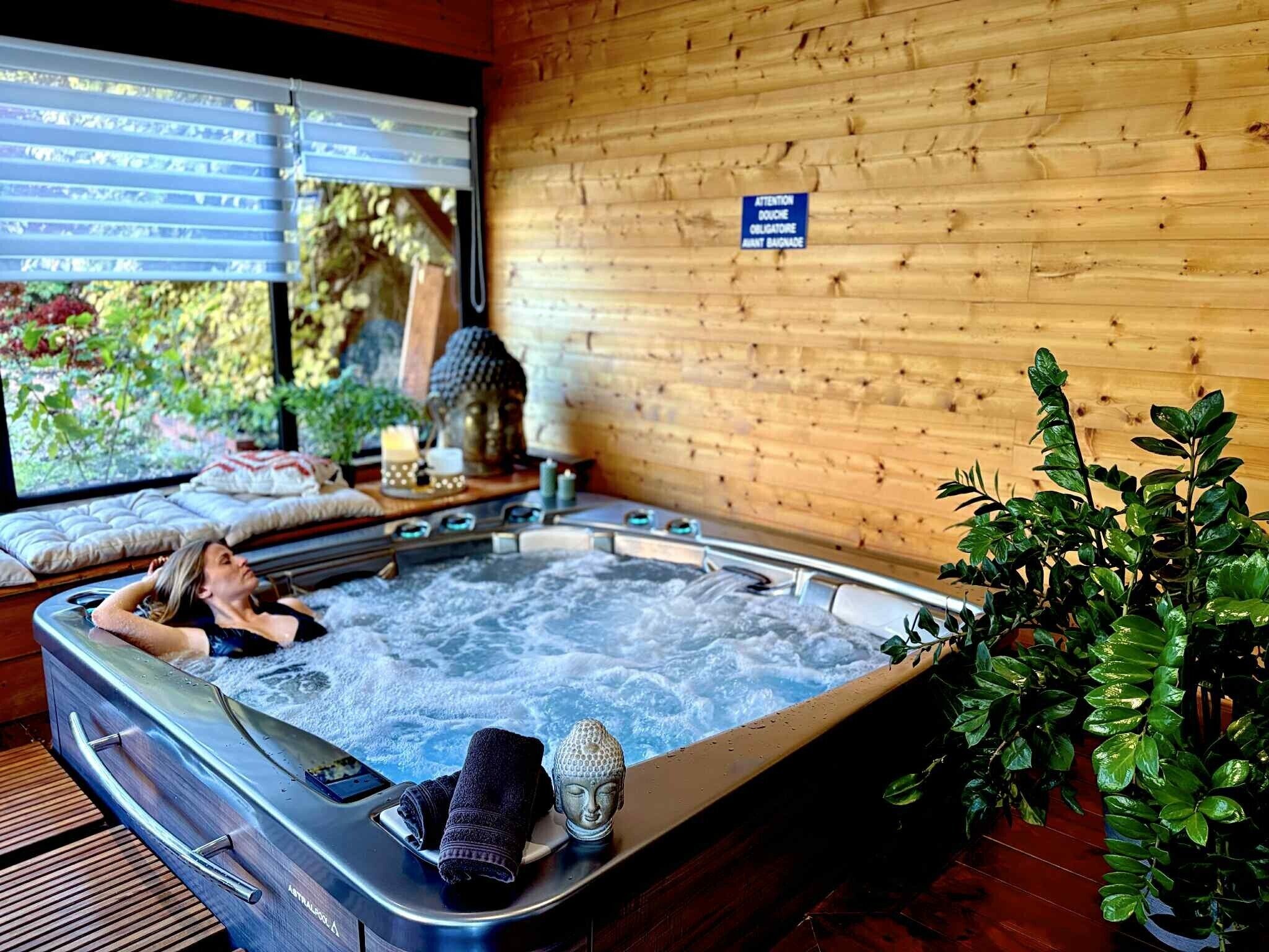 A spa room with a hot tub, a wooden wall, and a sign warning of crocodiles.