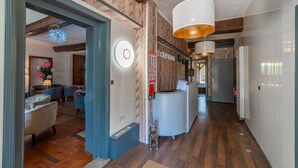 A reception area with a wooden floor, a reception desk, and a wall-mounted clock.
