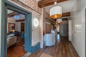 Zona de recepción con suelo de madera, un mostrador y un reloj en la pared.