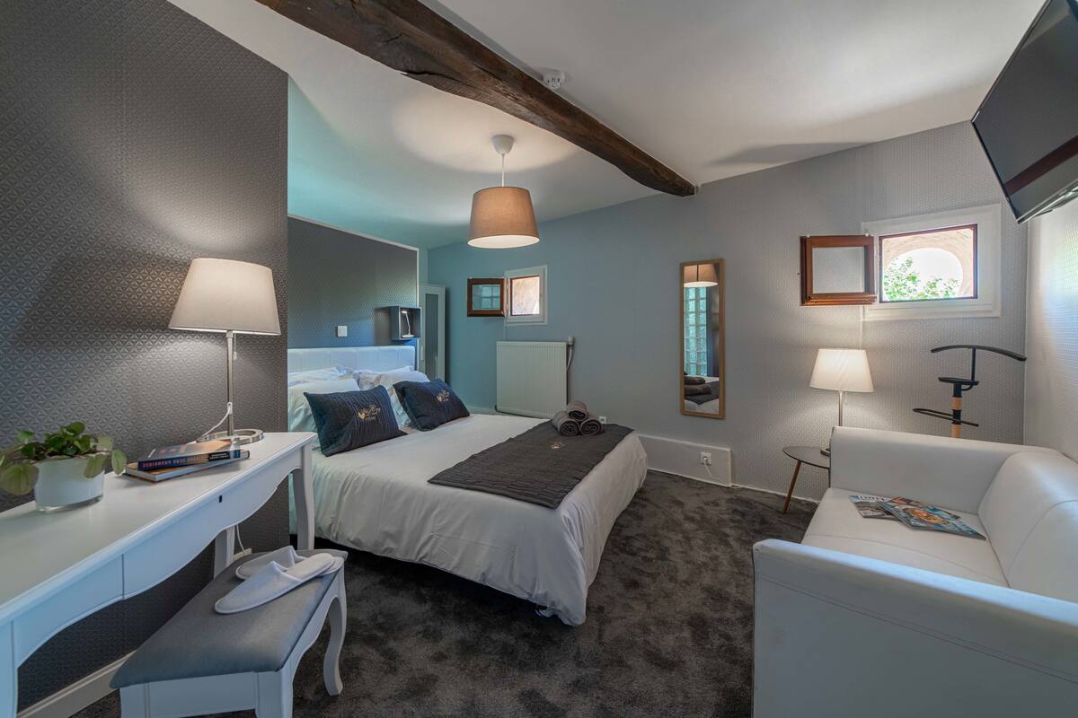Une chambre à coucher moderne, comprenant un lit, une table de chevet, un bureau et une chaise.