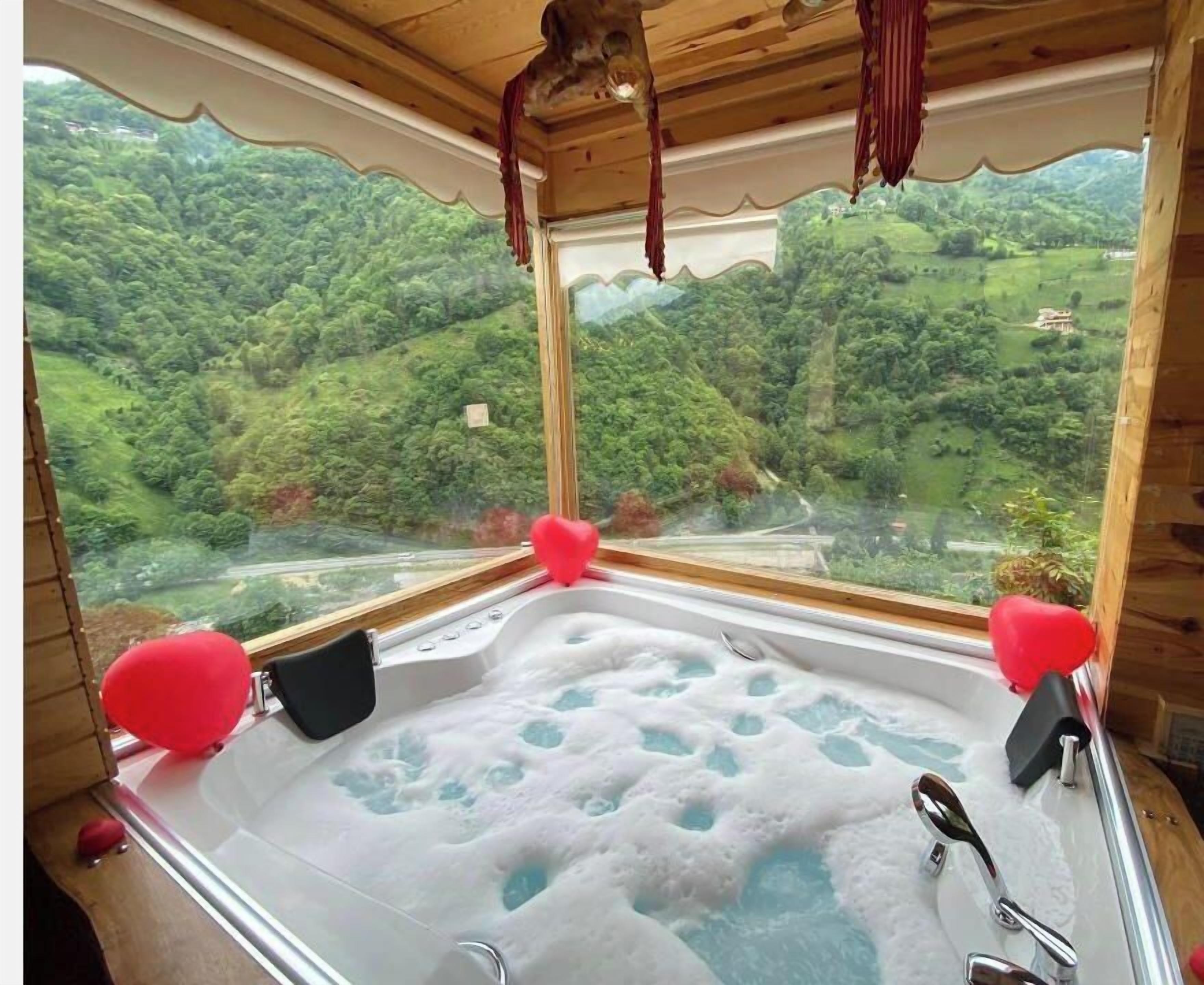 Ein Whirlpool mit Blick auf eine üppige, grüne Landschaft.