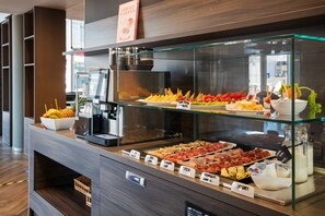 Un buffet proposant une variété de plats et un coin café.